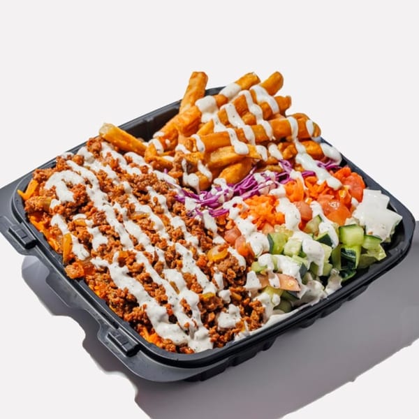 Loaded fries with ground meat, salad, and white sauce in a black takeout container.